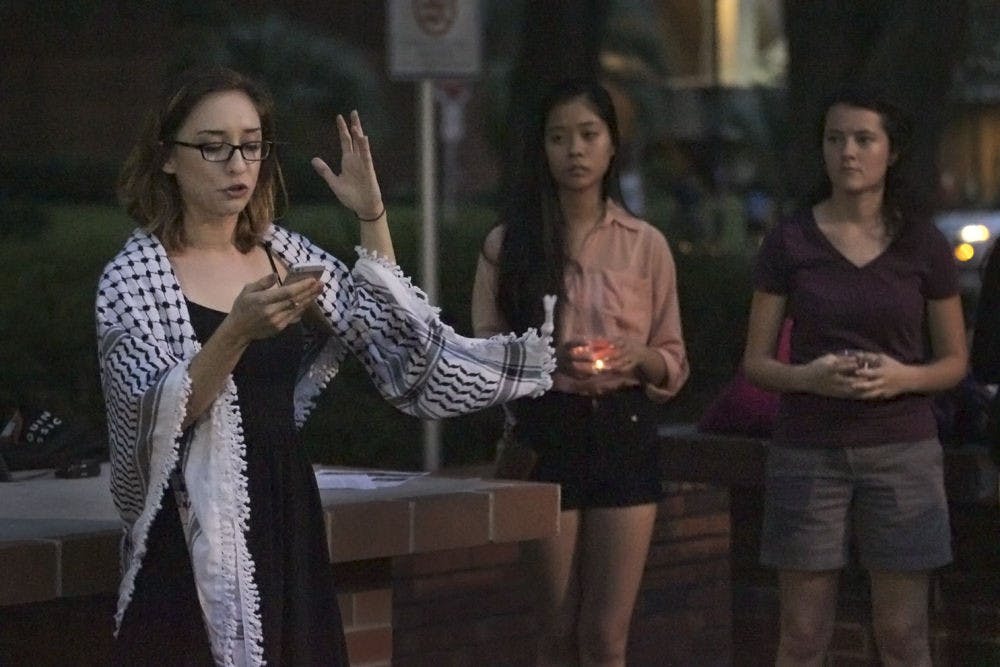 <p>Lara Alqasem, a member of the Radical Students Alliance and then-UF political science sophomore, speaks during a candlelight vigil in support of refugees in 2015. “You only leave home when home is the mouth of a shark,” she said. “No one puts their children on boats unless the boat is safer than the land.”</p>