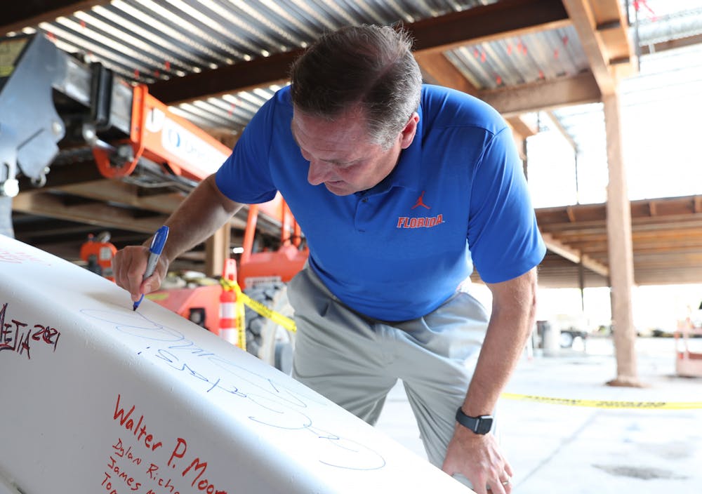 Dan Mullen signs a beam at Tuesday's ceremony for the new football center.