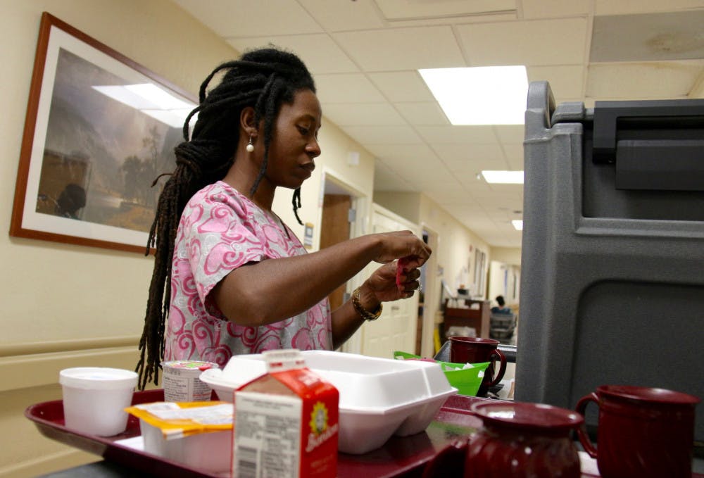 Charell Lane, a certified nursing assistant, prepares lunch for residents of Parklands Care Center on Labor Day. She said she didn’t mind working on Monday, although many workers had the day off.