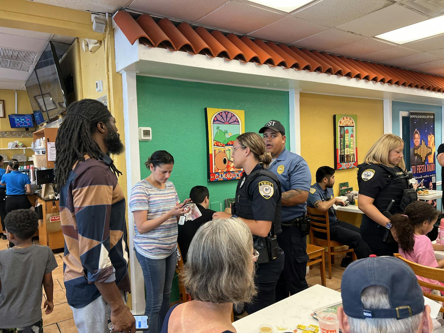 Oficiales de Gainesville Police Department hablando con ciudadanos en el evento &quot;Coffee with a Cop&quot; el miércoles 5 de junio de 2024.