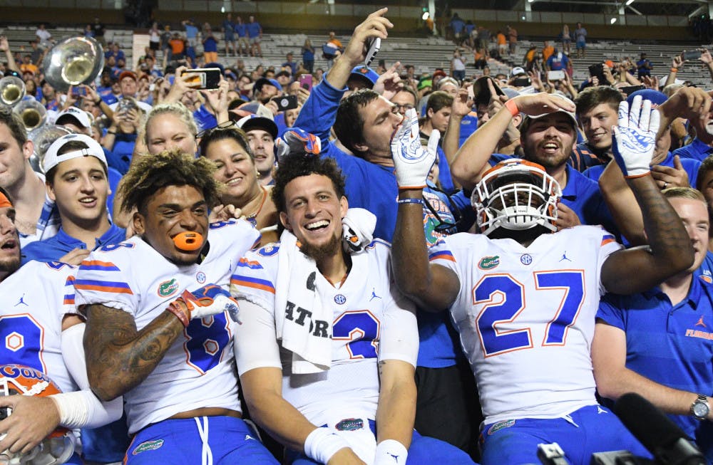 <p>Quarterback Feleipe Franks celebrates with fans and teammates Trevon Grimes and Dameon Pierce following a 47-21 win at Tennessee. </p>
