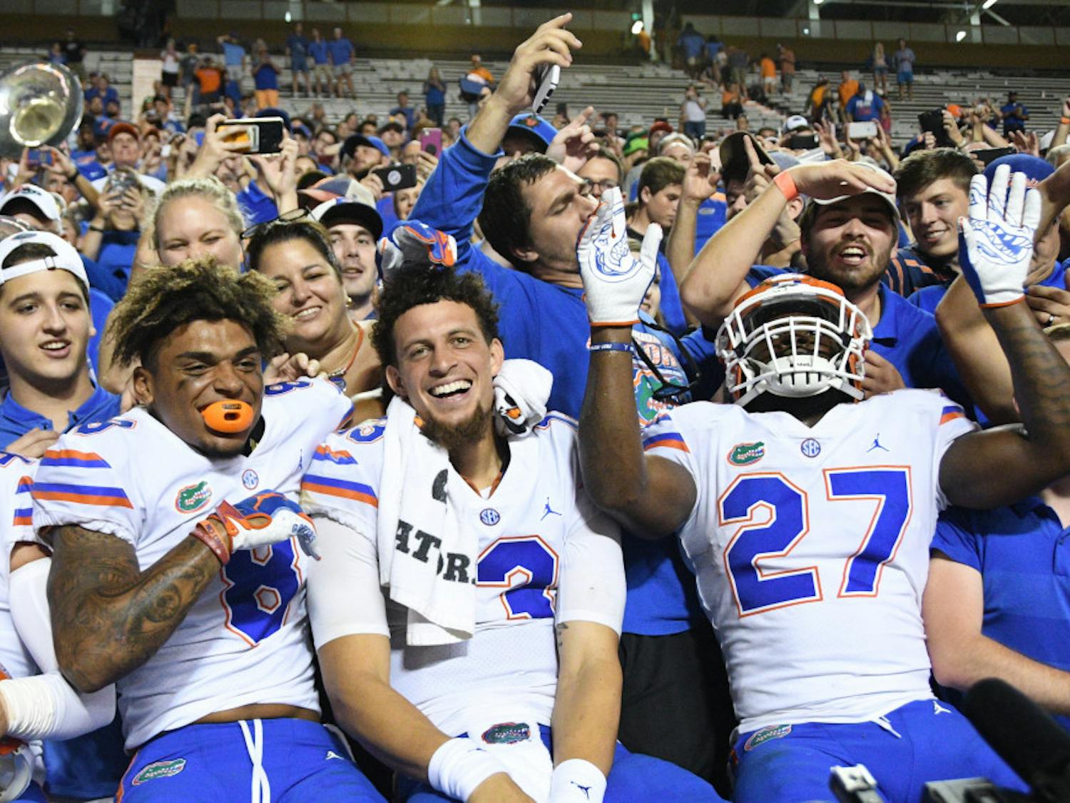 Quarterback Feleipe Franks celebrates with fans and teammates Trevon Grimes and Dameon Pierce following a 47-21 win at Tennessee.
