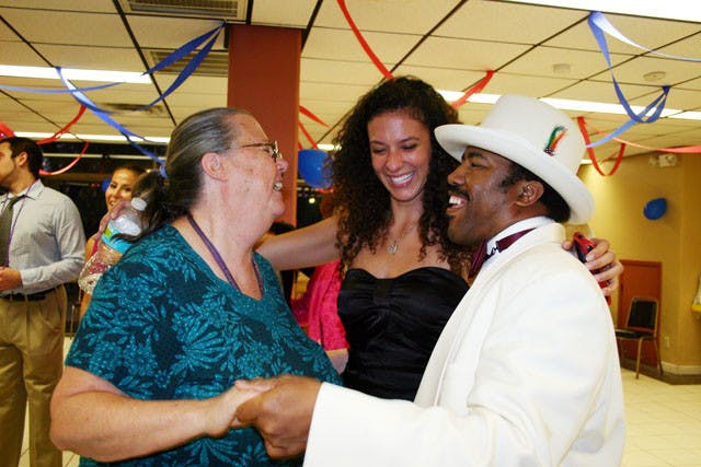 Hazel Porter, 62, and Jason Davis, 39, dance to "Build Me Up Buttercup" with 19-year-old digital media sophomore Miriam Miyara Tuesday night at Oak Park's senior prom, which was hosted by Gamma Eta Sorority Inc. and Pi Lambda Phi fraternity.