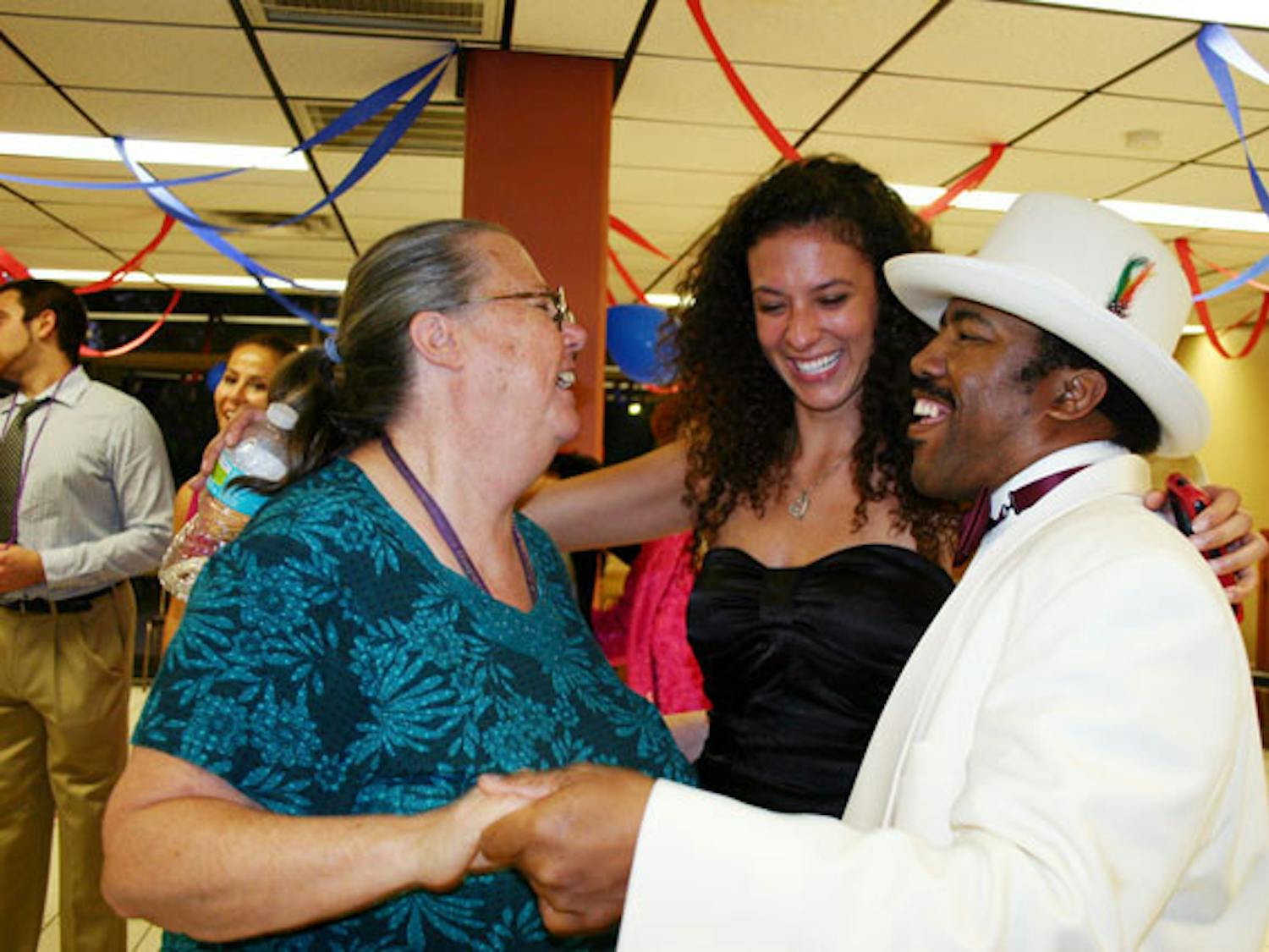Hazel Porter, 62, and Jason Davis, 39, dance to "Build Me Up Buttercup" with 19-year-old digital media sophomore Miriam Miyara Tuesday night at Oak Park's senior prom, which was hosted by Gamma Eta Sorority Inc. and Pi Lambda Phi fraternity.