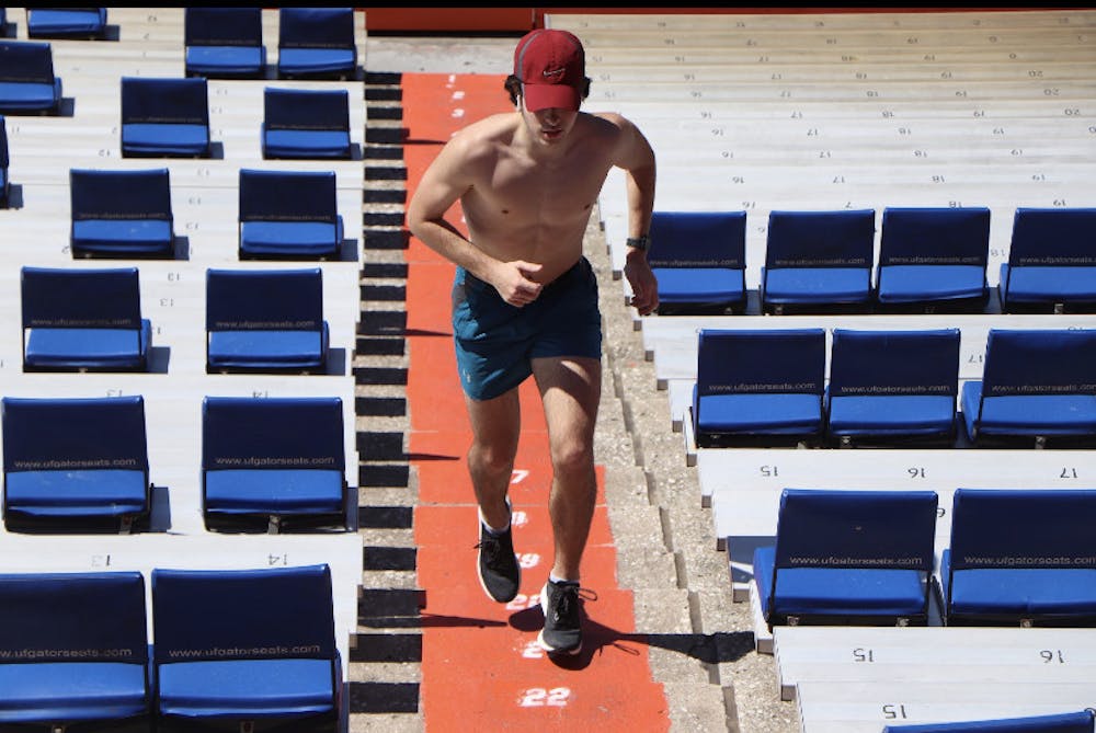 <p>Adam Conybear, a 21-year-old junior studying computer science, runs up the stairs at Ben Hill Griffin Stadium on March 9.</p>