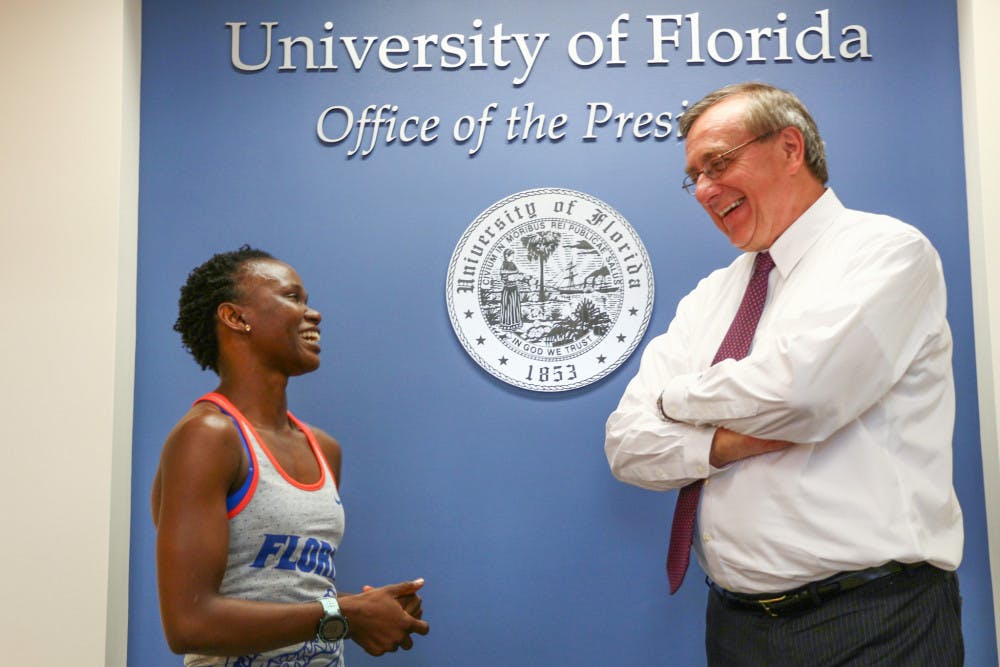 <p dir="ltr">Nelly Kadag, a 30-year-old UF interdisciplinary ecology doctoral student, talks with UF President Kent Fuchs on Wednesday before completing the 22 Pushup Challenge, which educates people about veteran suicide rates. She nominated him for the challenge on Sept. 9.</p>