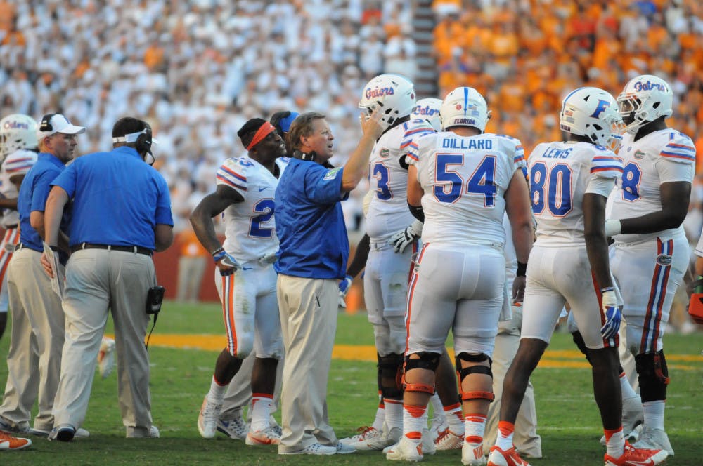 <p>Coach Jim McElwain, center, talks with UF offensive lineman Martez Ivey (73) during Florida's 38-28 loss to Tennessee on Sept. 24, 2016, in Knoxville</p>