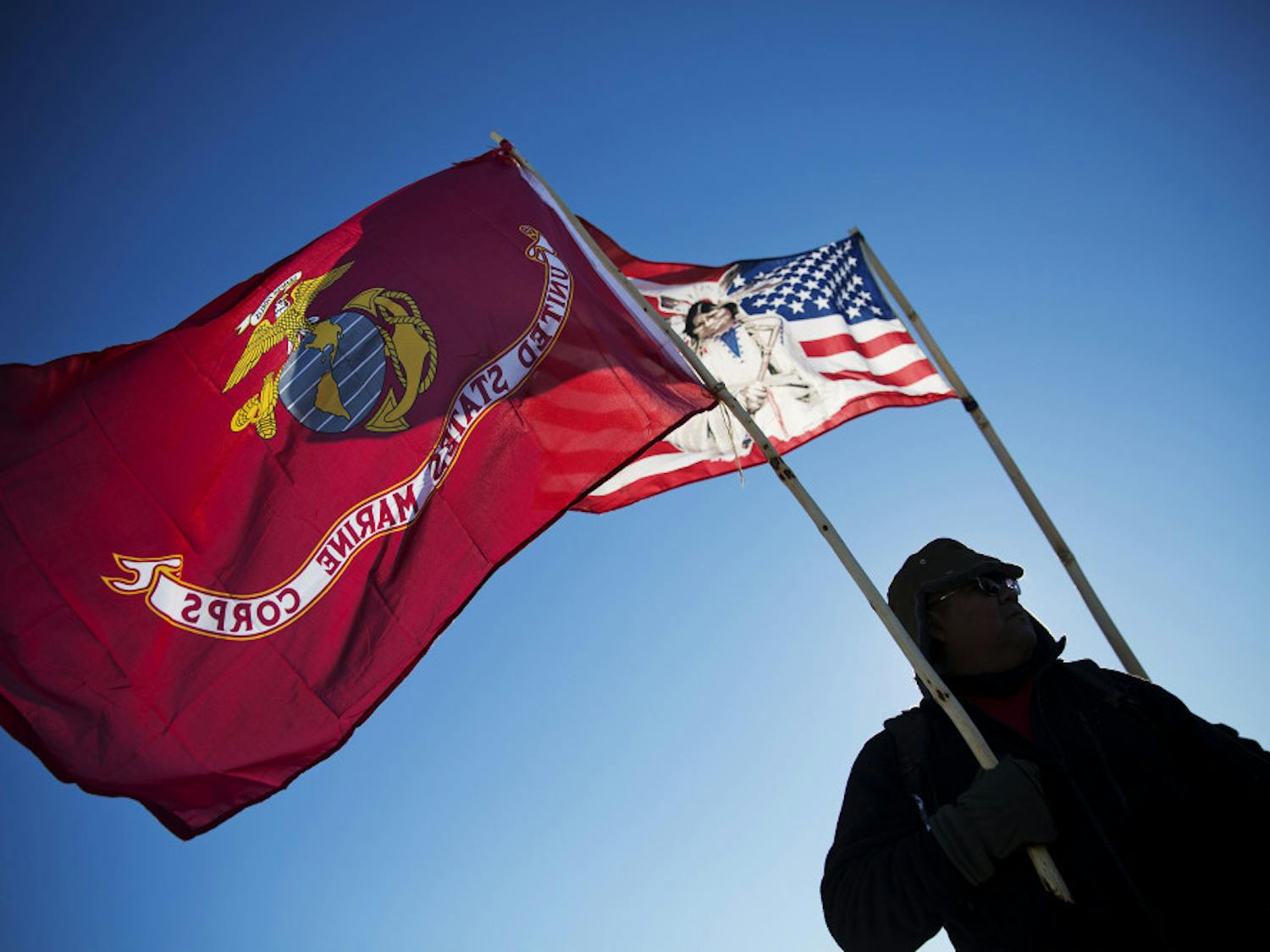 Marine Corps veteran and Northern Paiute and Pit River Native American Audie Noneo, of Susanville, Calif., holds the Marine Corps flag at the Oceti Sakowin camp where people have gathered to protest the Dakota Access oil pipeline in Cannon Ball, N.D., Sunday, Dec. 4, 2016. The U.S. Army Corps of Engineers said Sunday it won't grant easement for the Dakota Access oil pipeline in southern North Dakota.