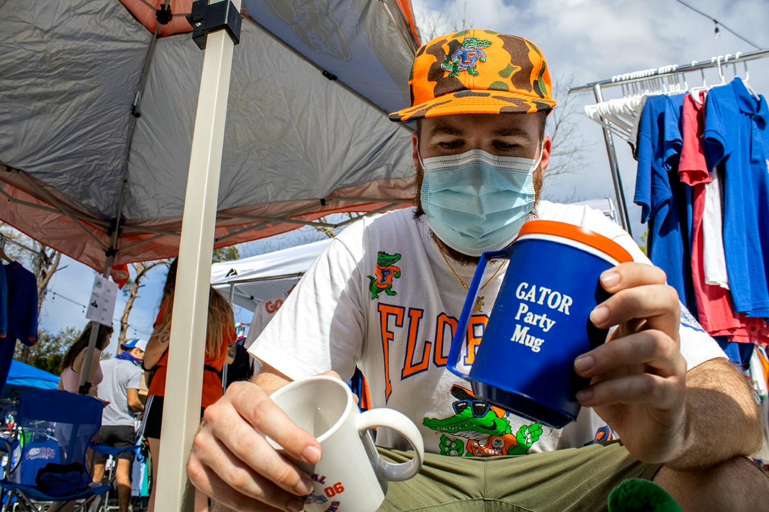 Josh Rittenour, owner of vintage Gator shop Dave's Freshly Used, goes through a bin of merchandise at his pop-up stand on Sunday, Feb. 28, 2021. (Photo by Chasity Maynard) 