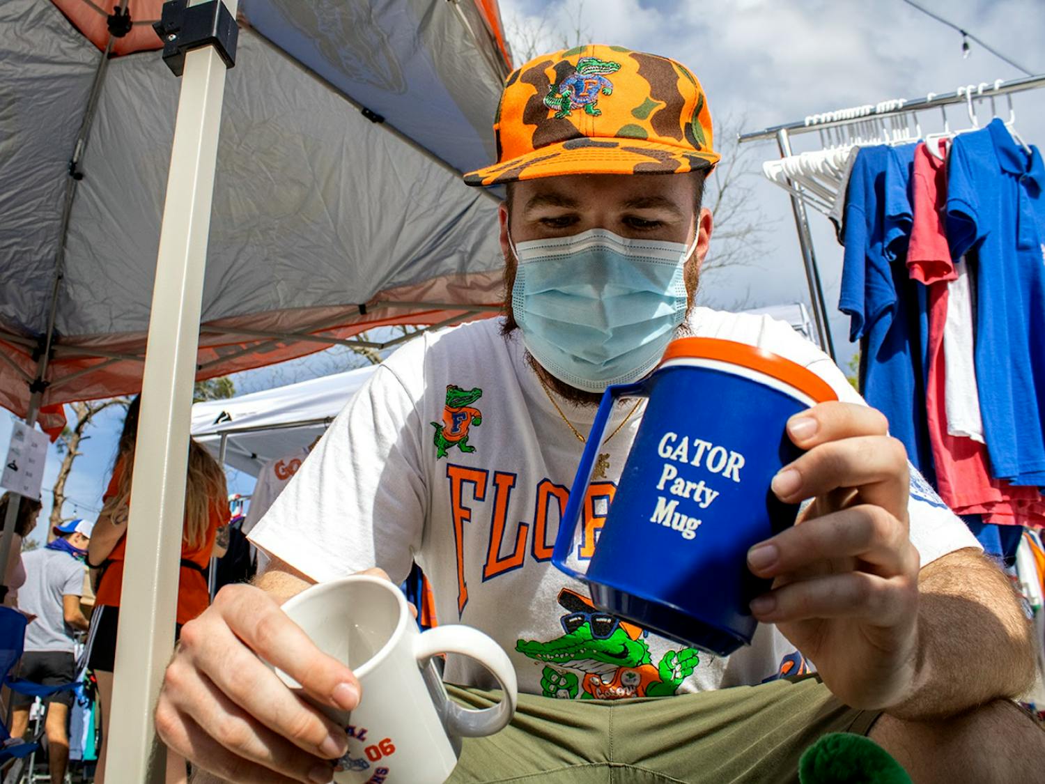 Josh Rittenour, owner of vintage Gator shop Dave's Freshly Used, goes through a bin of merchandise at his pop-up stand on Sunday, Feb. 28, 2021. (Photo by Chasity Maynard)