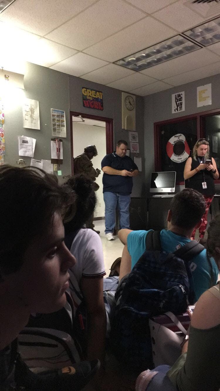 Richard Doan and his classmates wait to be escorted out of Marjory Stoneman Douglas High School by a SWAT team, following a school shooting that left at least 17 dead. 