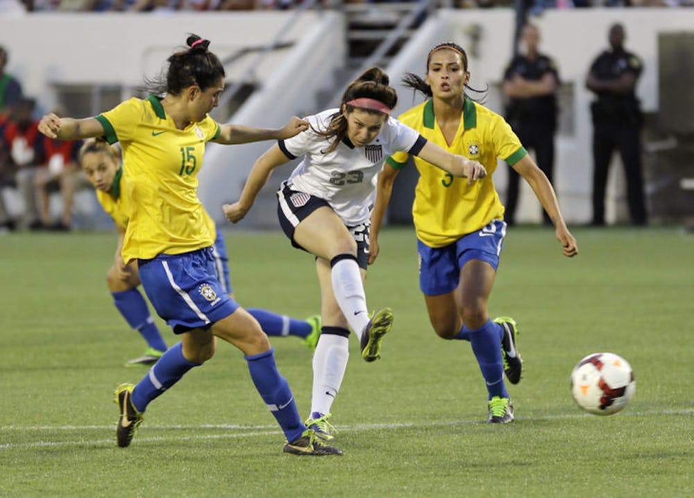 <p>Erika Tymrak (23) scores a goal between Brazil midfielder Bia (15) and defender Calandrini (3) during a friendly soccer match in Orlando on Sunday. The U.S. Women's National Team beat Brazil 4-1.</p>