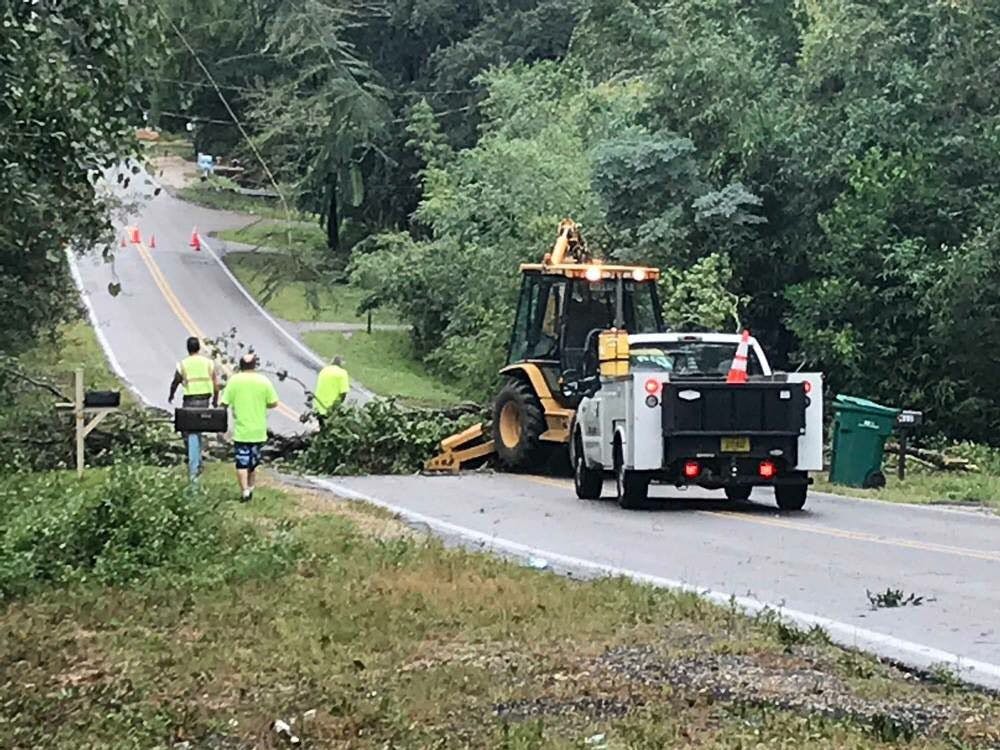 Workers try to clear fallen trees off a road in Niceville, Florida.&nbsp;