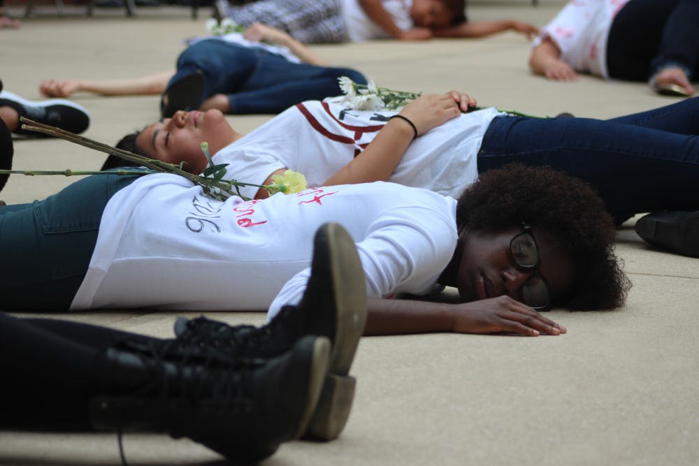 Medens Gerbier, 22, lies motionless Wednesday as a part of a "die-in" protest on Wednesday outside the UF Levin College of Law.