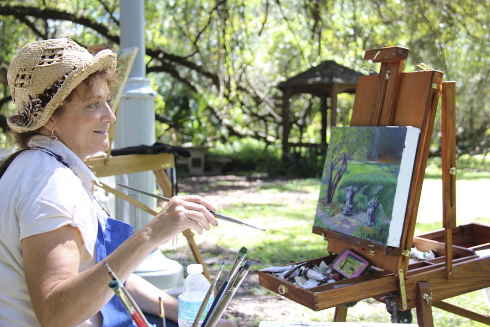 <p class="p1"><span class="s1">Tina Lanza Corbett, of the High Springs Art Co-Op, paints a landscape during the Kanapaha Botanical Gardens “Paint Out” event Saturday. Artists were invited to come and be inspired by the beauty around them.</span></p>