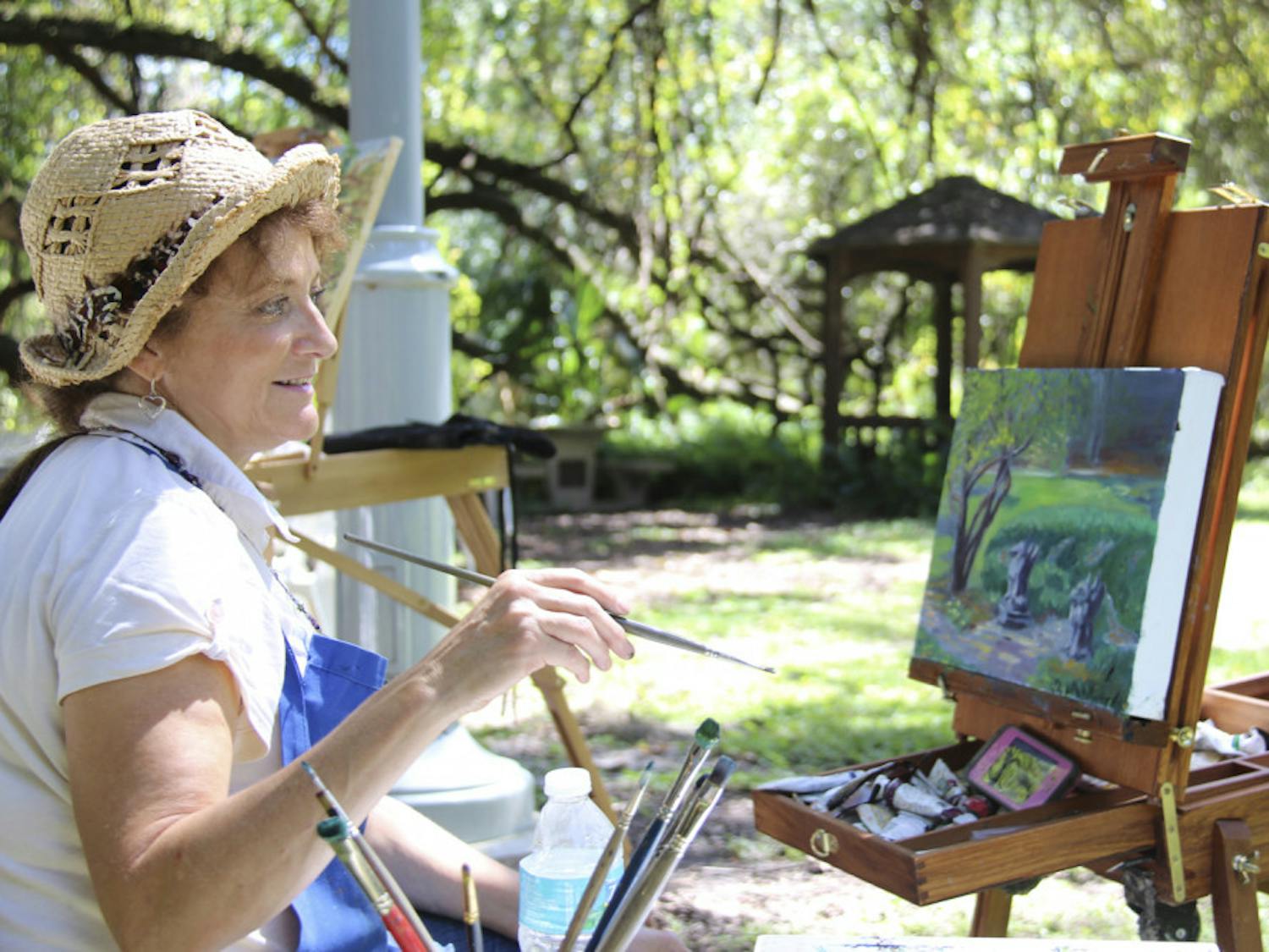 Tina Lanza Corbett, of the High Springs Art Co-Op, paints a landscape during the Kanapaha Botanical Gardens “Paint Out” event Saturday. Artists were invited to come and be inspired by the beauty around them.