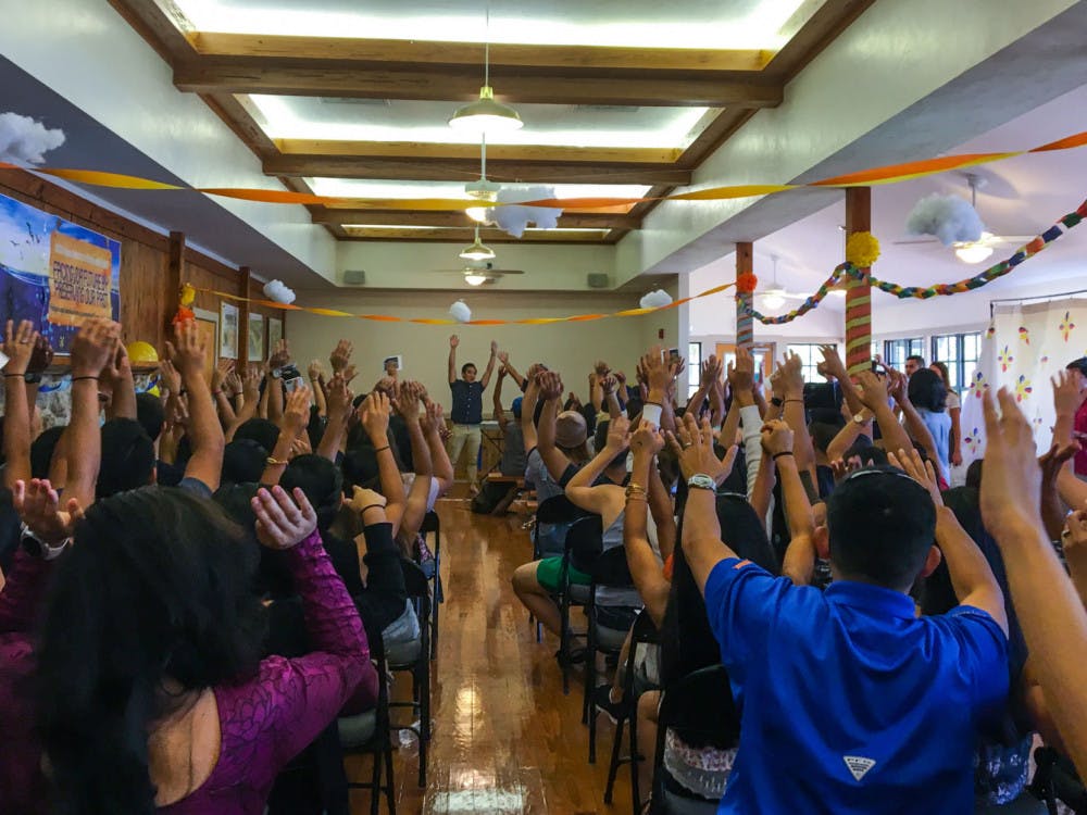 Students raise their hands in preparation for the “Mabuhay Roller Coaster,” a traditional Filipino greeting, on Sunday afternoon at the opening ceremony for Filipino-American History Month. Sunday's event at Lake Wauburg kicked off the monthlong celebration.