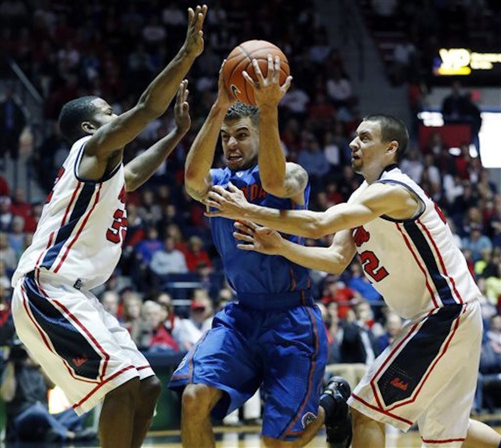 <p>Scottie Wilbekin is guarded by Ole Miss' Jarvis Summers, left, and Marshall Henderson in No. 2 Florida's 75-71 victory on Saturday.</p>