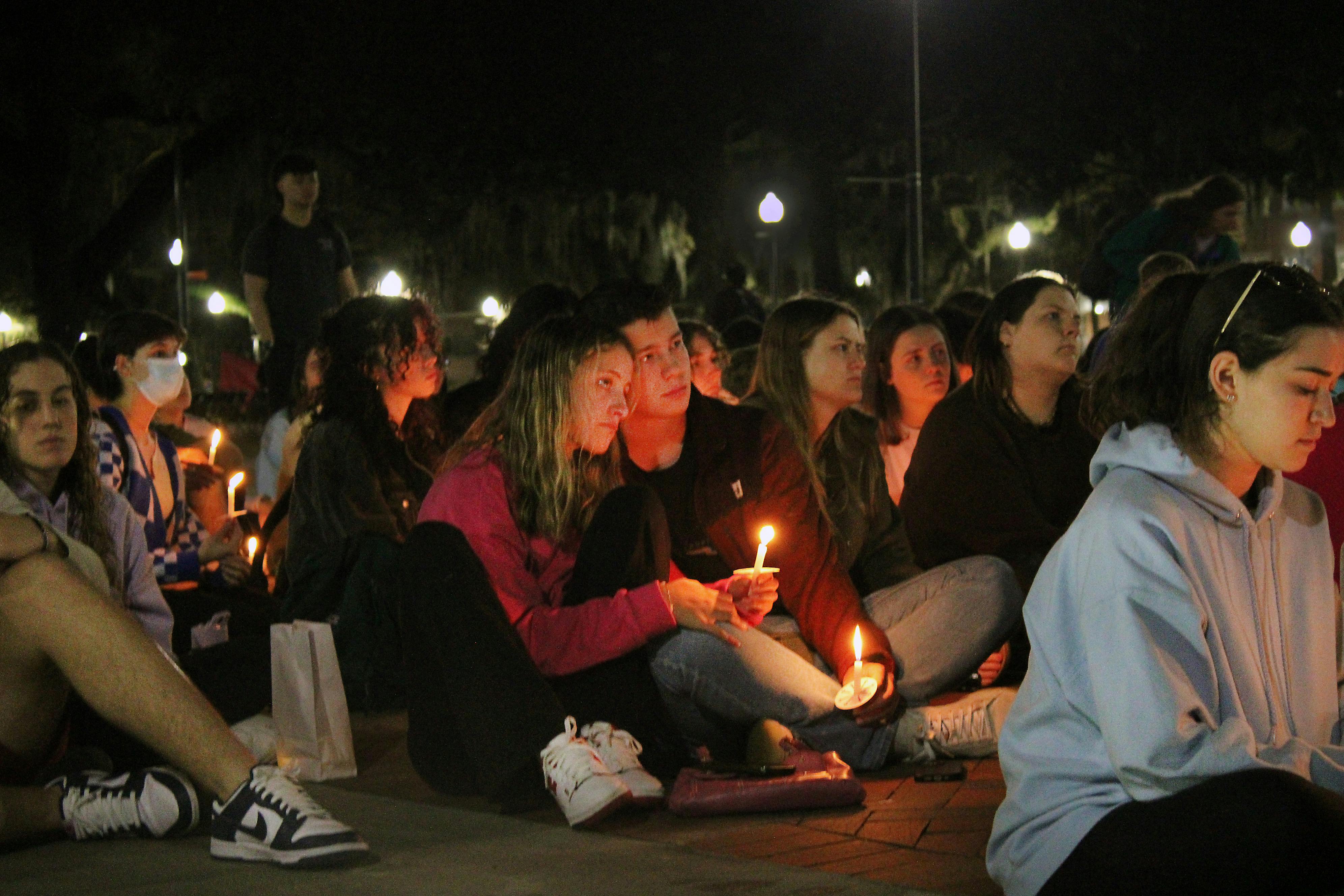 Rachel Taylor (left) and Will Marshall (right) honor the victims of the Marjory Stoneman Douglas shooting at the five year anniversary remembrance vigil at UF&#x27;s Plaza of the Americas Tuesday, February 14, 2023.