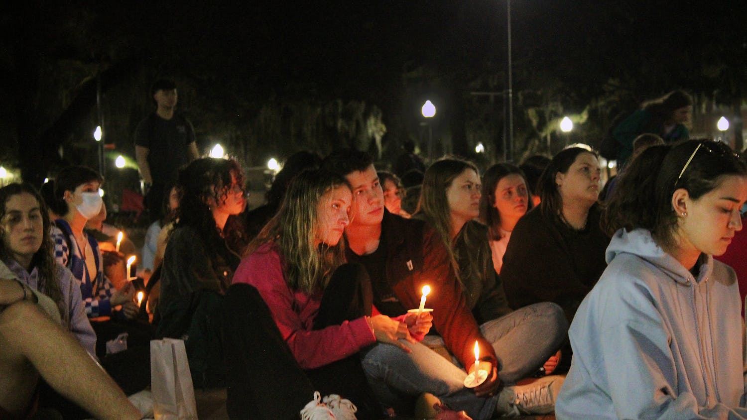 Rachel Taylor (left) and Will Marshall (right) honor the victims of the Marjory Stoneman Douglas shooting at the five year anniversary remembrance vigil at UF&#x27;s Plaza of the Americas Tuesday, February 14, 2023.