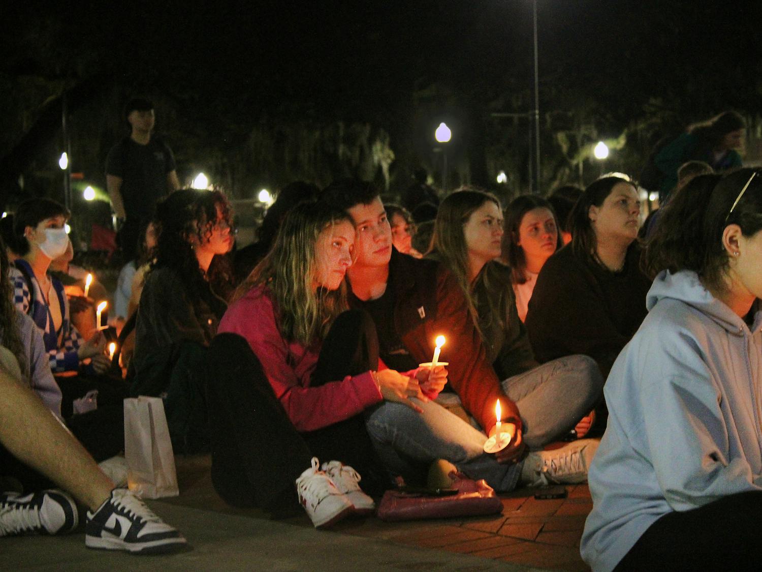 Rachel Taylor (left) and Will Marshall (right) honor the victims of the Marjory Stoneman Douglas shooting at the five year anniversary remembrance vigil at UF&#x27;s Plaza of the Americas Tuesday, February 14, 2023.