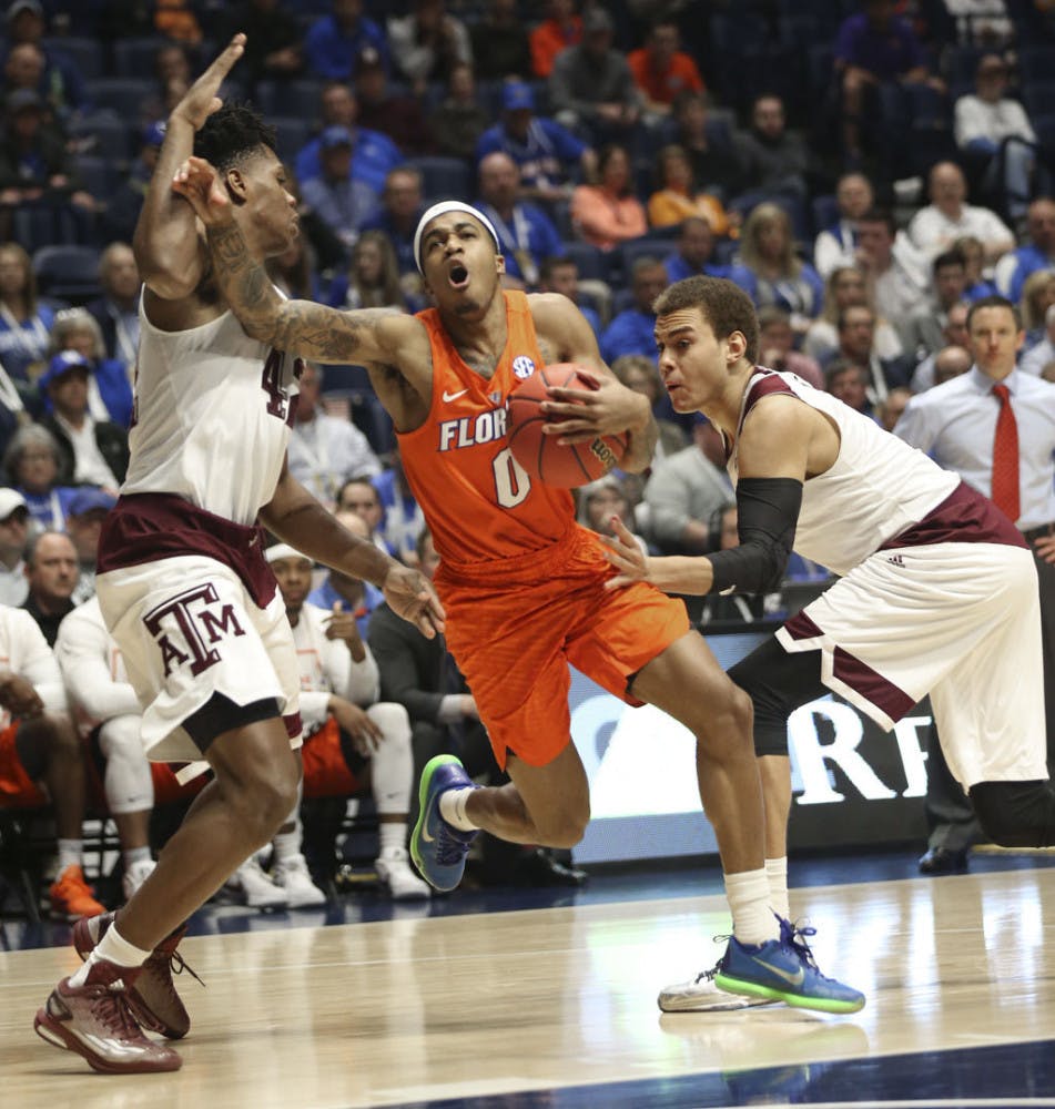 Florida's Kasey Hill, center, tries to drive between Texas A&amp;M's Tavario Miller, left, and DJ Hogg, right, during the second half of an NCAA college basketball game in the Southeastern Conference tournament in Nashville, Tenn., Friday, March 11, 2016. (AP Photo/John Bazemore)
