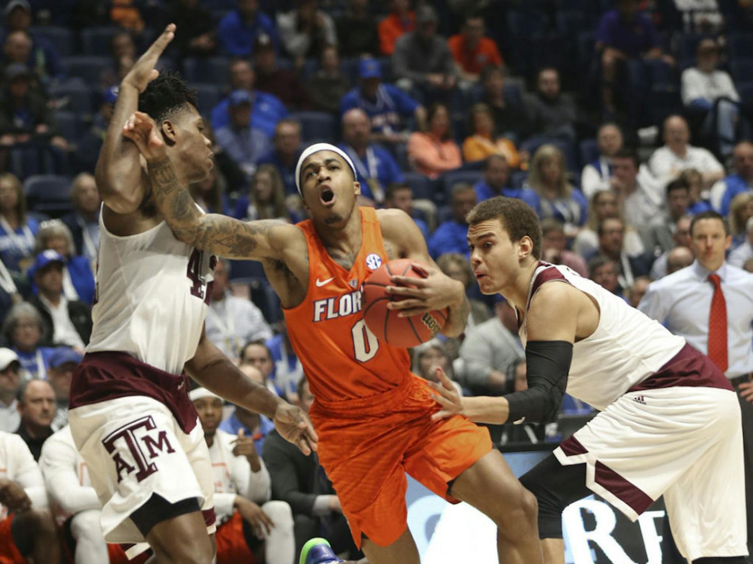 Florida's Kasey Hill, center, tries to drive between Texas A&amp;M's Tavario Miller, left, and DJ Hogg, right, during the second half of an NCAA college basketball game in the Southeastern Conference tournament in Nashville, Tenn., Friday, March 11, 2016. (AP Photo/John Bazemore)