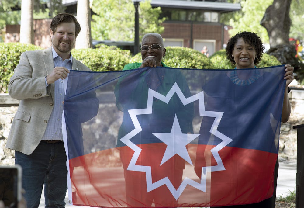 Gainesville Mayor Lauren Poe (left), Vivian Filer, executive director of the Cotton Club Museum and Cultural Center (middle), and Gainesville city Diversity, Equity, and Inclusion leader Teneeshia Marshall (right) hold the Juneteenth flag on Thursday, May 20, 2021. 