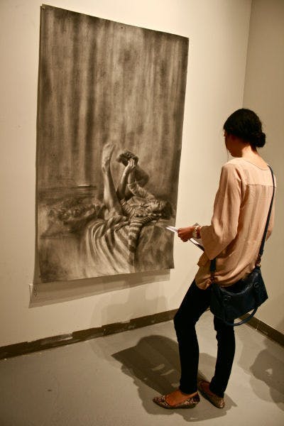 Amara Harnish, a 21-year-old UF English junior, admires the work of senior drawing student Kelly O’Brien at “TEASER: An Advanced Drawing Group Exhibition.” The event showcases drawing seniors’ works and will run through Thursday at the WARPhaus Gallery on Fourth Avenue.