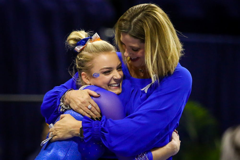 Florida coach Jenny Rowland hugs gymnast Alyssa Baumann after her beam routine during UF’s 198.15-198.125 win over Oklahoma on Jan. 26, 2018. 