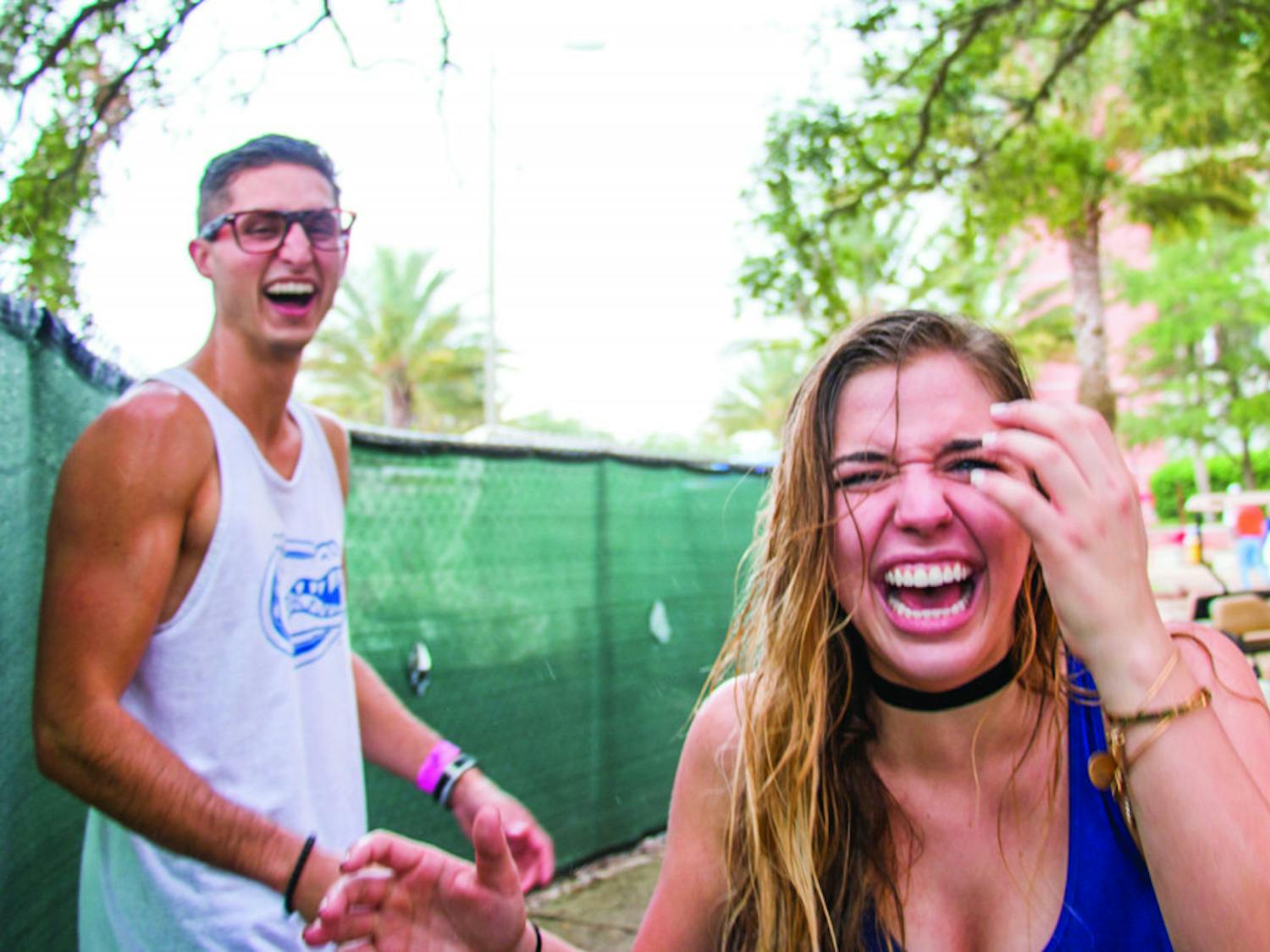 From left: UF students Richard Minichiello and Sarah Galante laugh while facing the rain before the UF Homecoming football game on Saturday afternoon. They “couldn’t believe they got soaked,” said Galante.