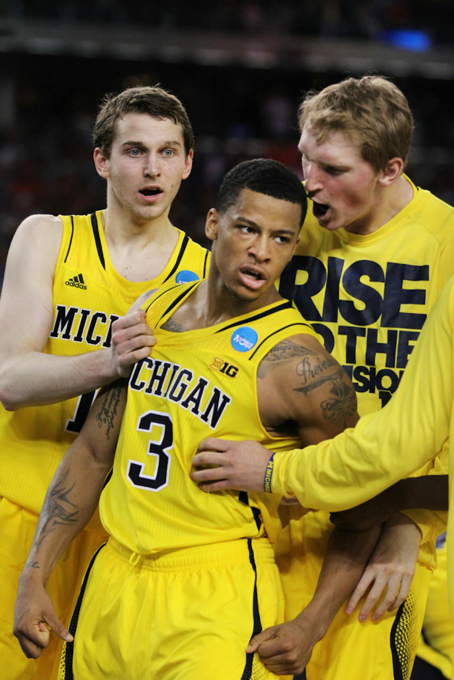 Guard Trey Burke (3) celebrates with his teammates during Michigan’s 87-85 overtime win against Kansas on March 29 in Arlington, Texas.