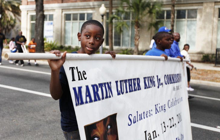 Jason Martin, 9, left, of William S. Talbot Elementary School, marches with his brother Jared Martin, 11, of Fort Clarke Middle School, in the Martin Luther King Jr. Day parade on Monday on West University Avenue.