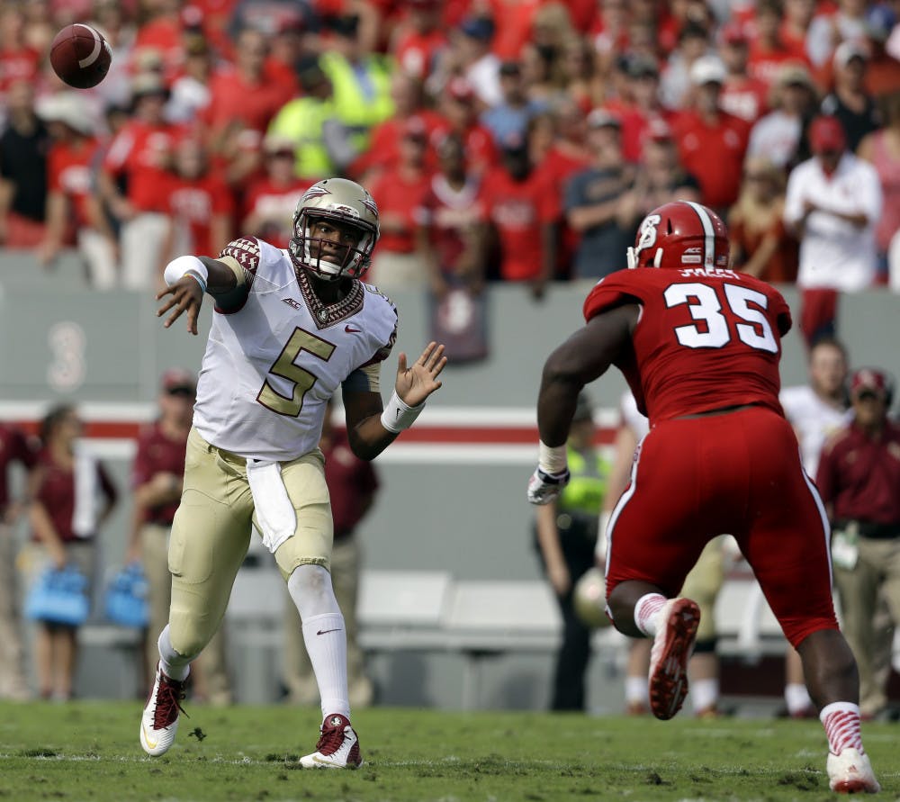 <p>Florida State quarterback Jameis Winston (5) throws a pass as North Carolina State's Kentavius Street (35) rushes during the first half of an NCAA college football game in Raleigh, N.C., Saturday, Sept. 27, 2014.</p>
