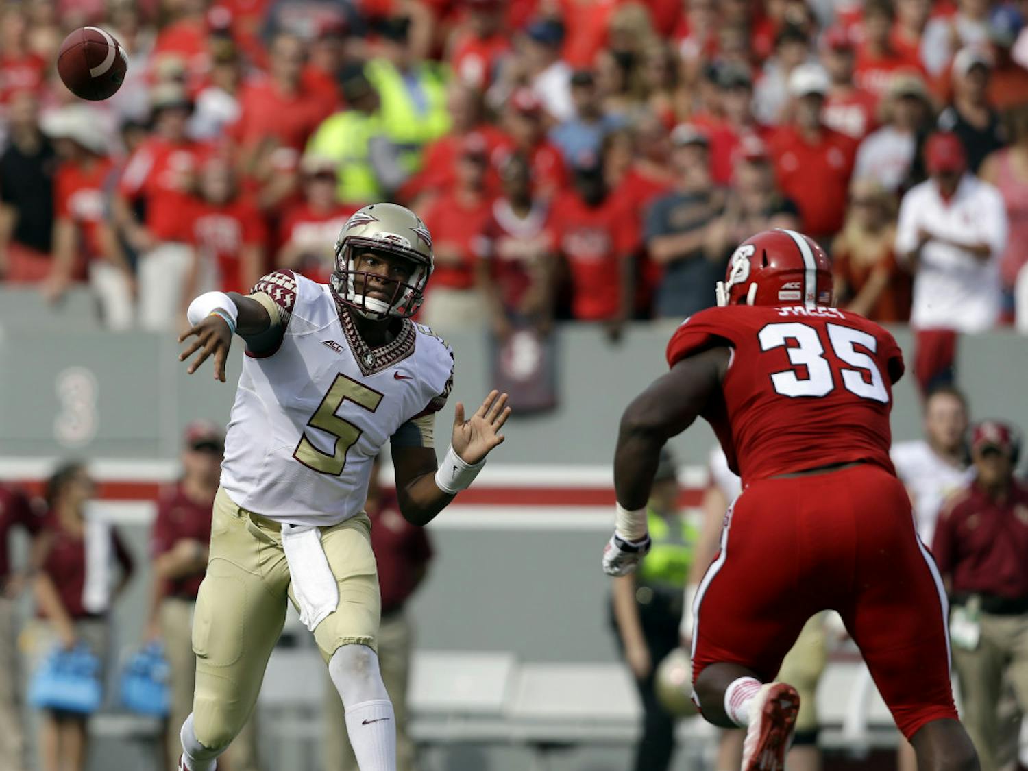 Florida State quarterback Jameis Winston (5) throws a pass as North Carolina State's Kentavius Street (35) rushes during the first half of an NCAA college football game in Raleigh, N.C., Saturday, Sept. 27, 2014.