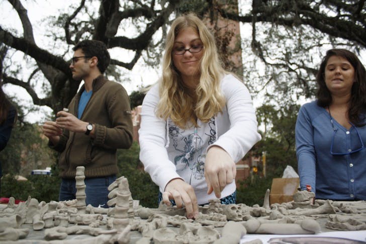 Janelle Pornovetz, 22, reorganizes clay bones on Turlington Plaza on Wednesday afternoon. Read a story about the One Million Bones project at alligator.org.