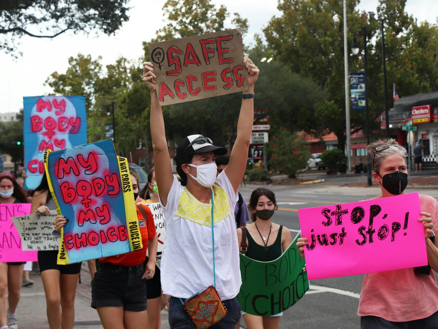 Protestors march down West University Avenue toward Southwest Sixth Street during the North Central Florida March for Reproductive Rights & Justice on Saturday, Oct. 2, 2021. The group of over 100 converged at Cora P. Roberson Park with another group that started at Depot Park.