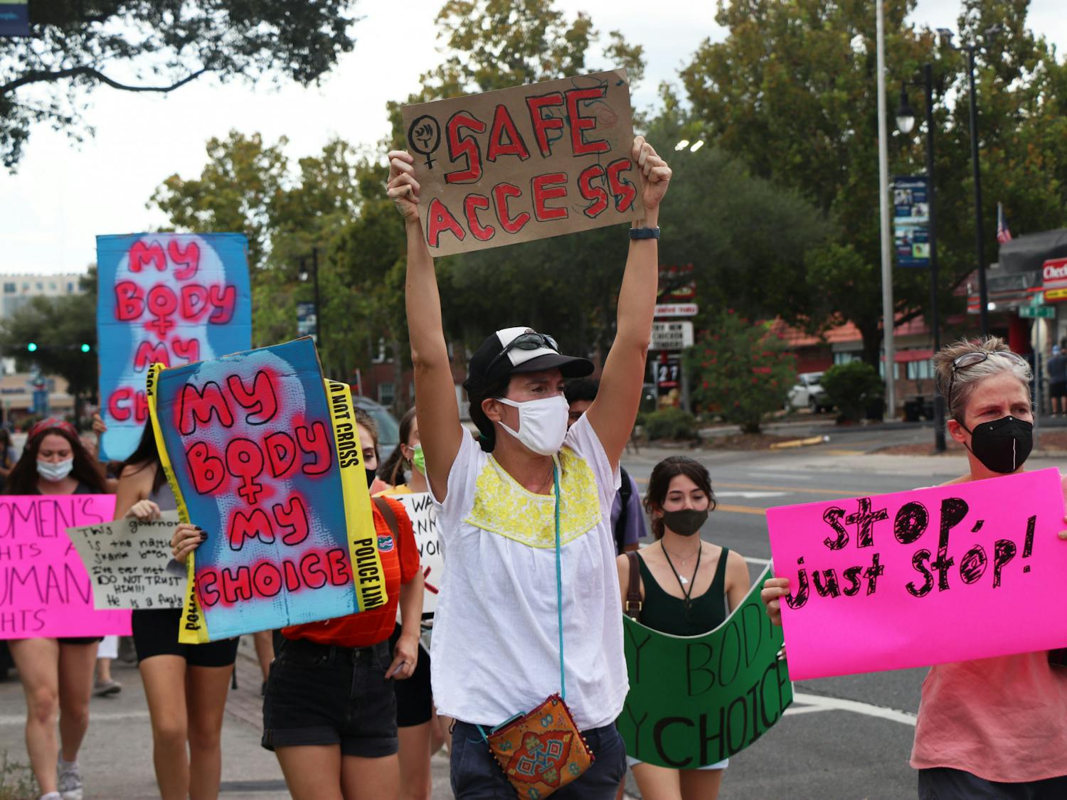 Protestors march down West University Avenue toward Southwest Sixth Street during the North Central Florida March for Reproductive Rights & Justice on Saturday, Oct. 2, 2021. The group of over 100 converged at Cora P. Roberson Park with another group that started at Depot Park.