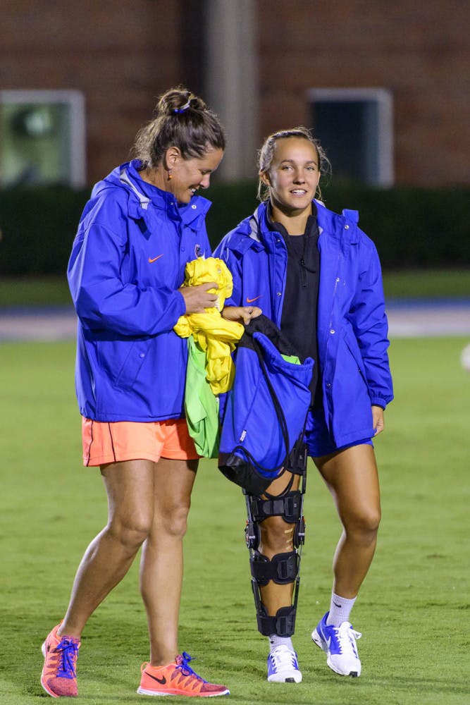 Karina Gutsche (right) walks on the field prior to Florida's 5-2 exhibition win against Florida International on Aug. 14 at James G. Pressly Stadium.
