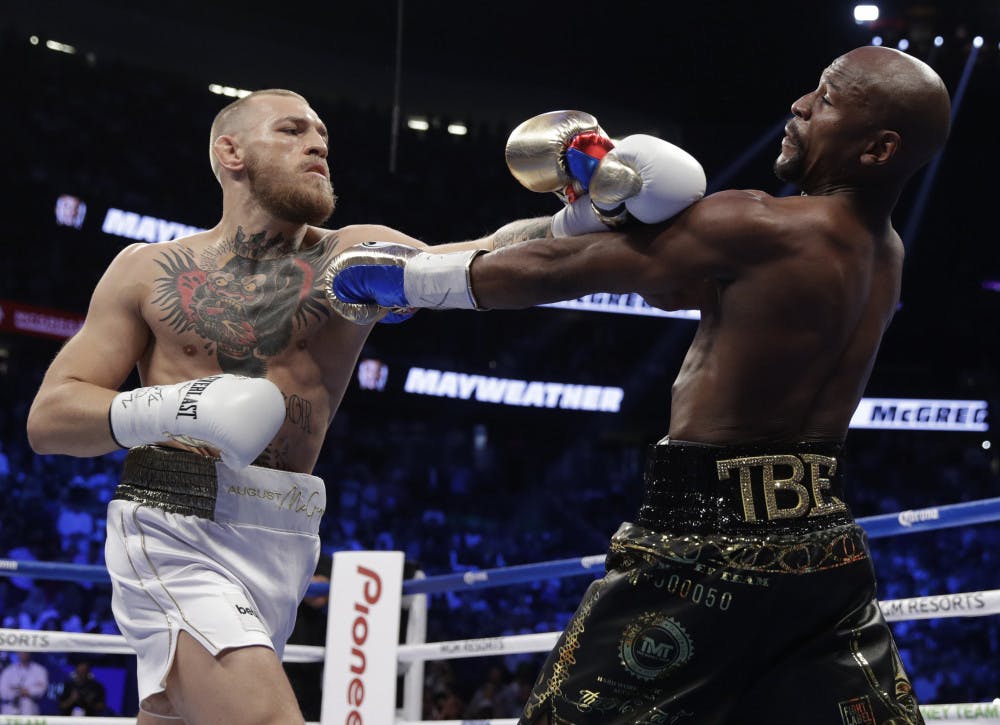 Floyd Mayweather Jr., right, fights Conor McGregor in a super welterweight boxing match Saturday, Aug. 26, 2017, in Las Vegas. (AP Photo/Isaac Brekken)