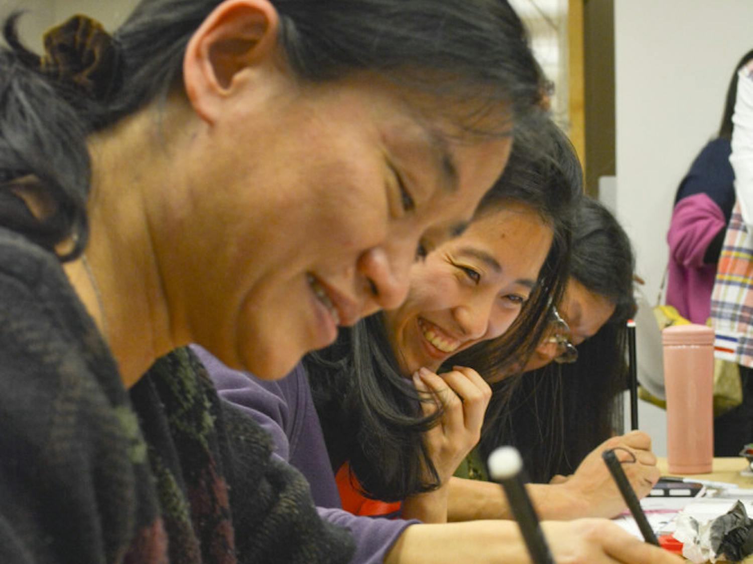 Wenhsing Wu, a lecturer in UF’s Department of Electrical and Computer Engineering, and Yii-Shyuan Chen, a UF genotyping lab technician, write Chinese calligraphy at the Samuel P. Harn Museum of Art.