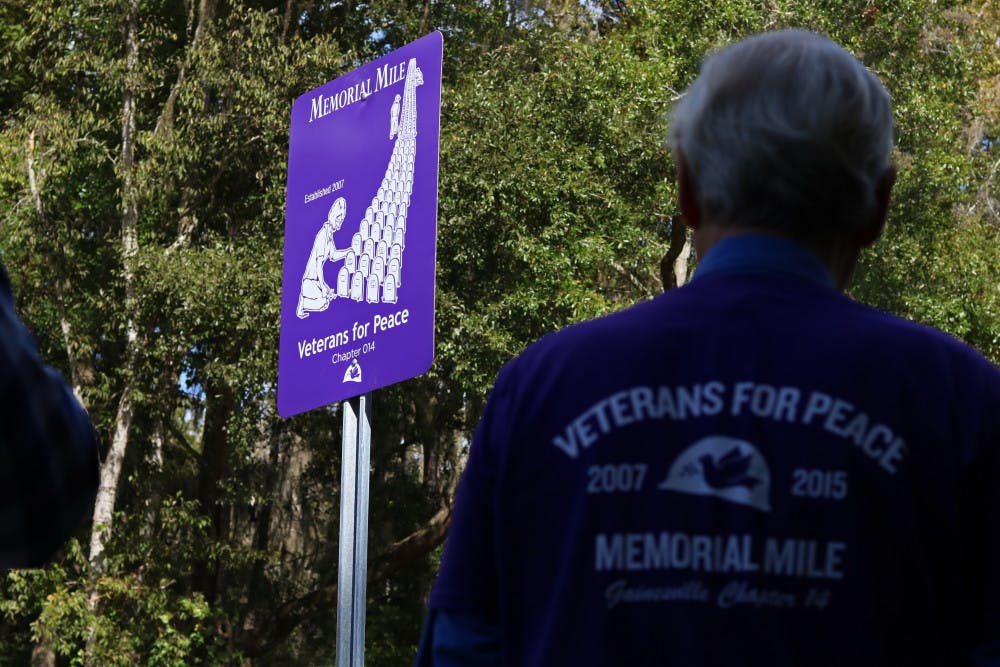 <p><span>Members of the organization Veterans for Peace look at the newly unveiled Memorial Mile marker on NW 8th Avenue Monday. During Memorial Day weekend each year, the organization places tombstones marking the names of every U.S. service member who has died in Iraq and Afghanistan.</span></p>