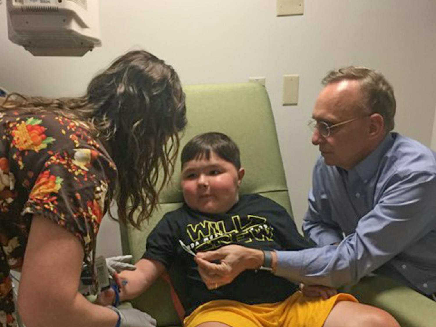 A UF Health Shands Hospital nurse tends to 9-year-old Will Barkoskie’s IV while Dr. Barry Byrne, a UF College of Medicine professor, looks on. Diagnosed with Duchenne muscular dystrophy, Barkoskie is receiving groundbreaking treatment at Shands.