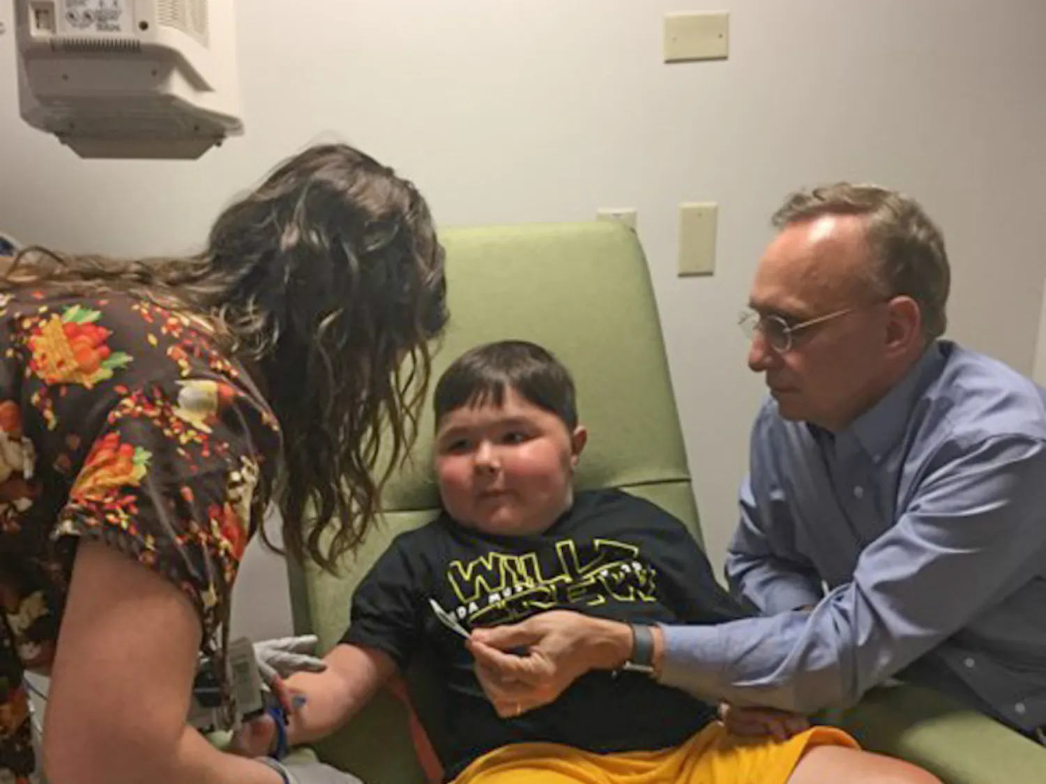 A UF Health Shands Hospital nurse tends to 9-year-old Will Barkoskie’s IV while Dr. Barry Byrne, a UF College of Medicine professor, looks on. Diagnosed with Duchenne muscular dystrophy, Barkoskie is receiving groundbreaking treatment at Shands.