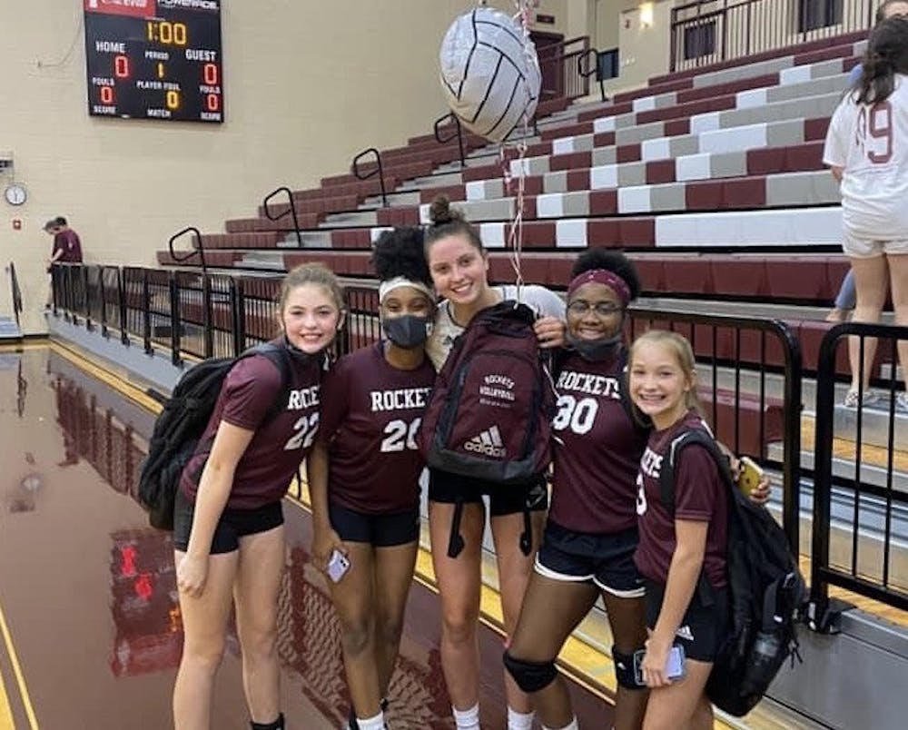 Florida's Merritt Beason (center), pictured while still in high school, poses with some of the middle school players she coached.