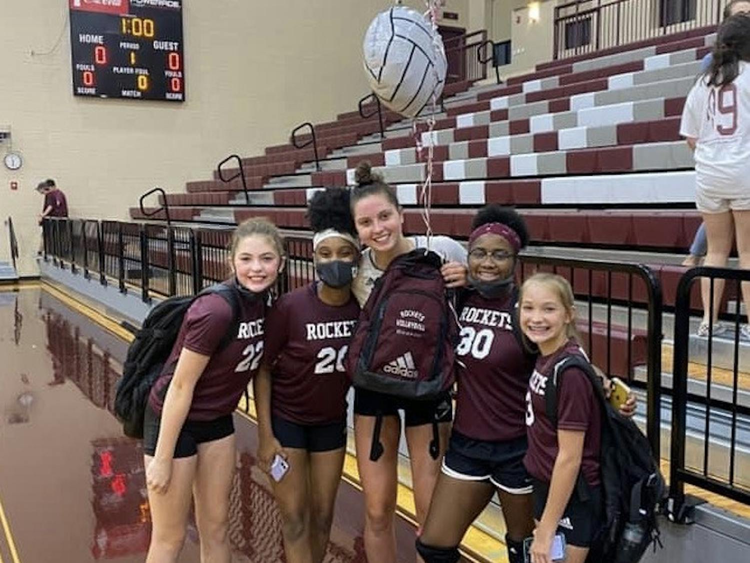 Florida's Merritt Beason (center), pictured while still in high school, poses with some of the middle school players she coached.
