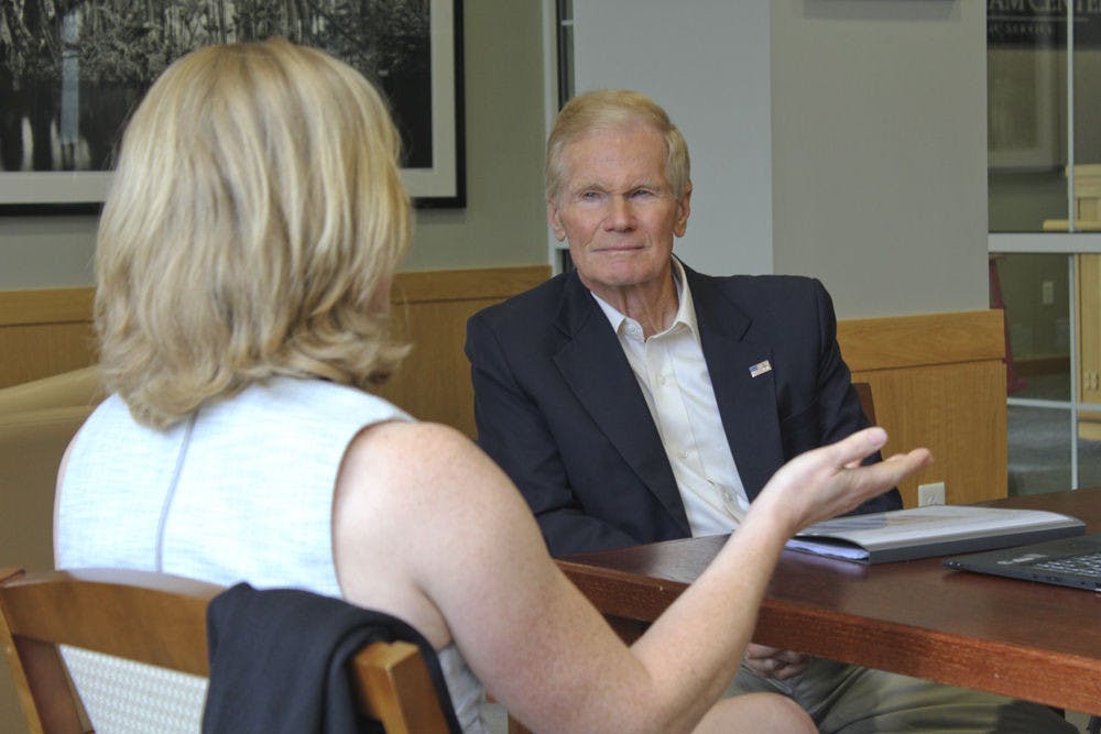 <p>U.S. Senator Bill Nelson speaks with UF geology researcher Andrea Dutton about rising ocean levels Aug. 31, 2015.</p>
