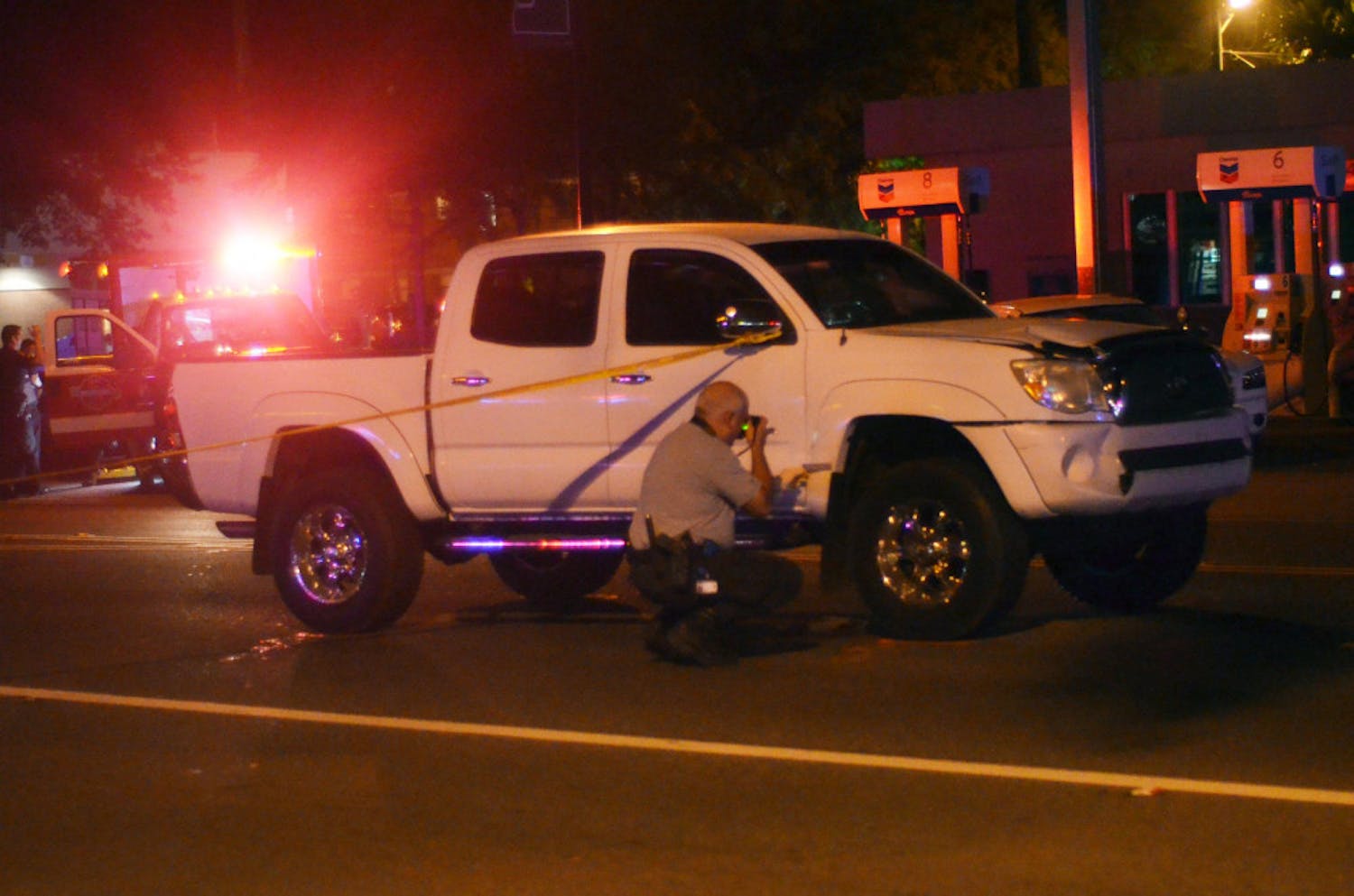A white Tacoma pickup truck shows damage after it hit a man crossing University Ave in front of Mother's Pub. 