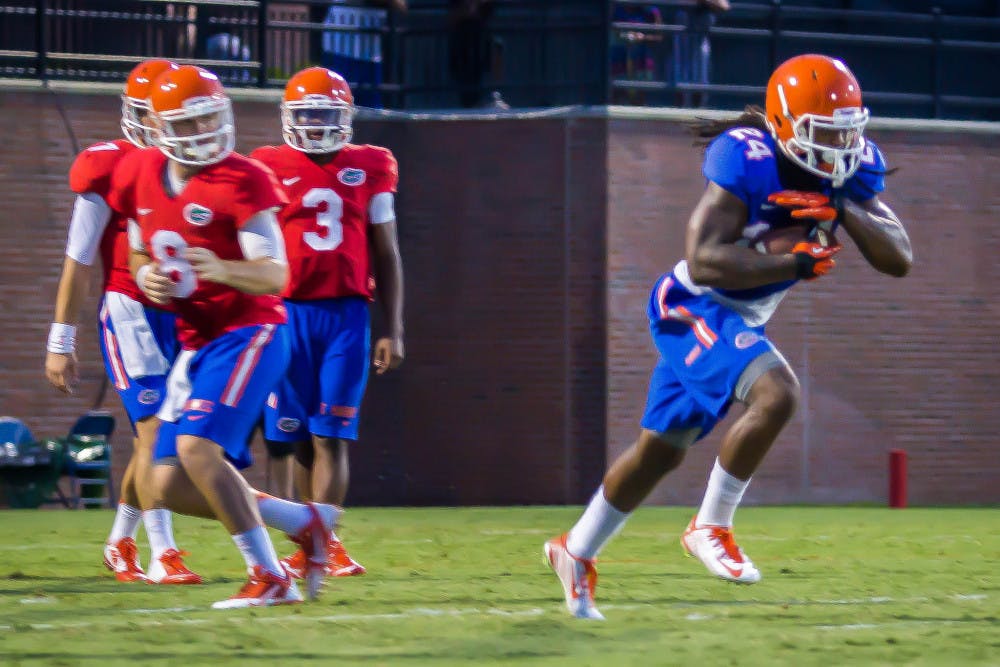 Skyler Mornhinweg (8) hands the ball off to Matt Jones (24) as Will Grier (7) and Treon Harris (3) look on during Florida's open practice on Aug. 8, 2014 at Donald R. Dizney Stadium. Head coach Jim McElwain revealed Wednesday that Mornhinweg would be transferring from Florida.
