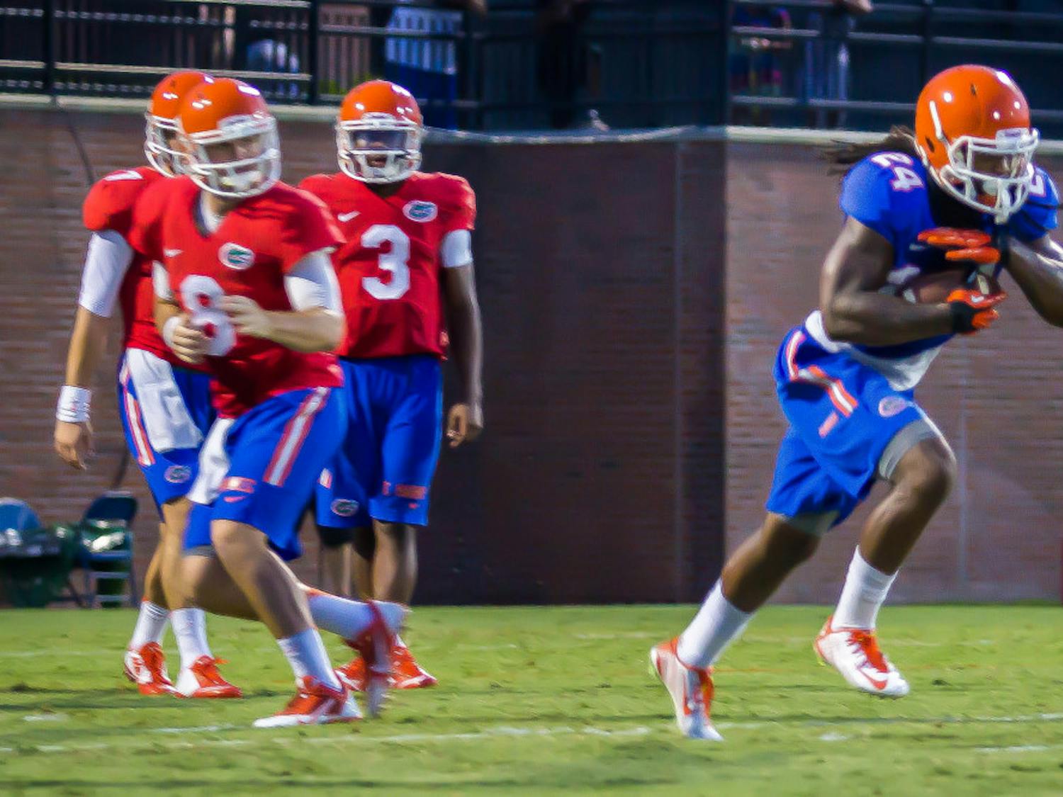 Skyler Mornhinweg (8) hands the ball off to Matt Jones (24) as Will Grier (7) and Treon Harris (3) look on during Florida's open practice on Aug. 8, 2014 at Donald R. Dizney Stadium. Head coach Jim McElwain revealed Wednesday that Mornhinweg would be transferring from Florida.